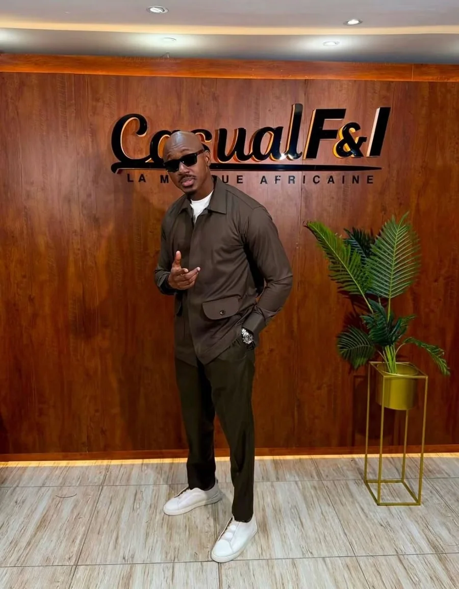 Le nom Casual F&I, la marque africaine, en lettres de métal sur le mur de bois de la boutique